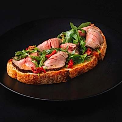 Блюдо от шеф-повара для гостей дегустации: Королевская брускетта с ростбифом, руколой и копчёными томатами.